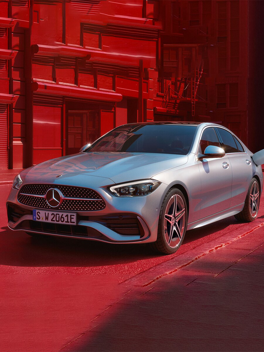 Image d'un couple au volant d'une Mercedes-Benz EQS en concession accompagné d'un distributeur.