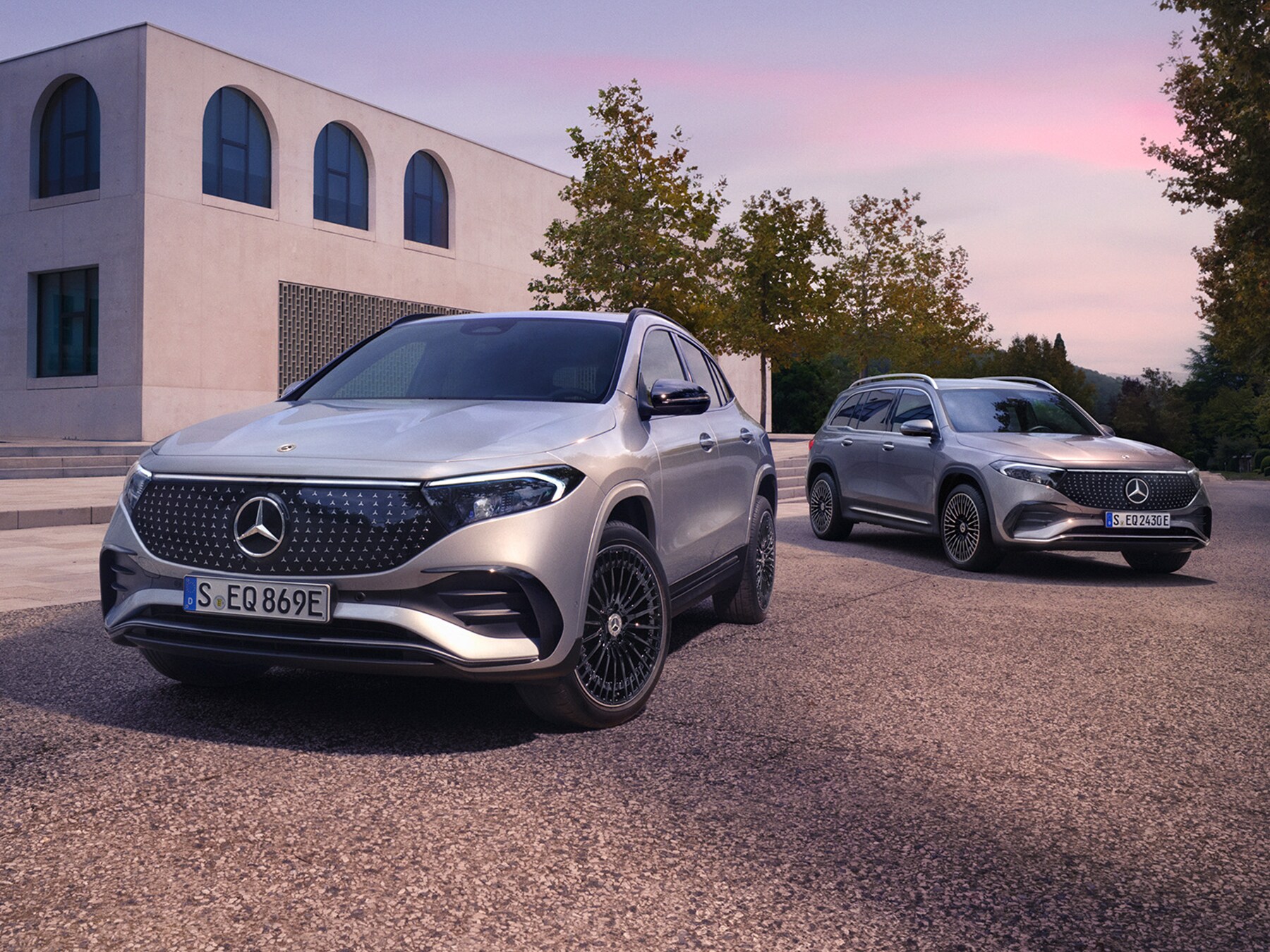 Deux Mercedes-Benz électriques stationnées devant un bâtiment moderne.