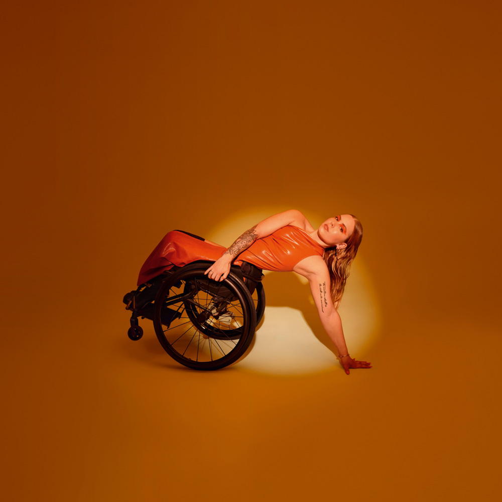 Qualité | Aides à la conduite | Mercedes-Benz Un véhicule adapté aux personnes à mobilité réduite : la Classe C Break dans une vue de 3/4 arrière et une femme en fauteuil roulant.