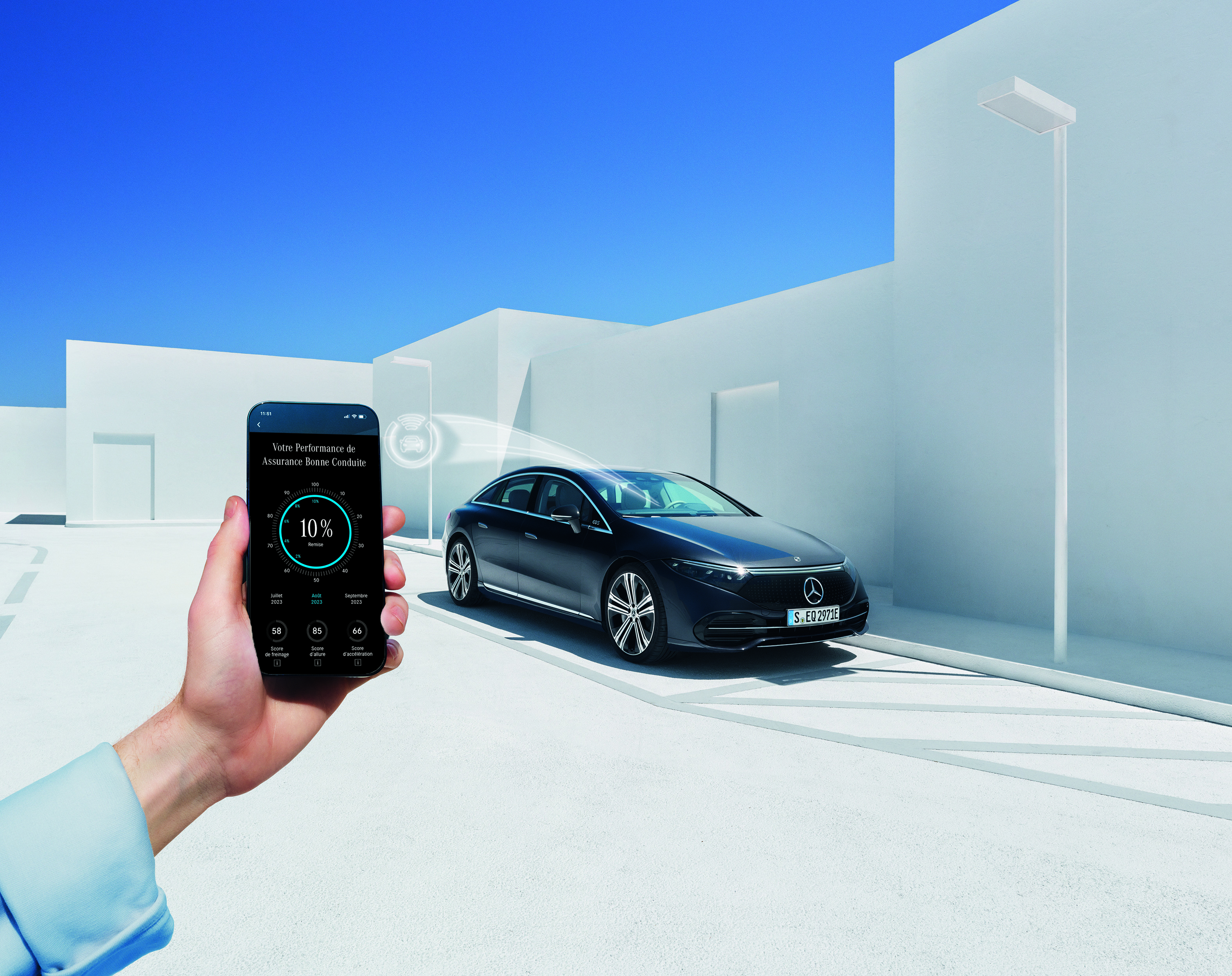 Mercedes-Benz EQC Une femme regarde son téléphone portable à coté d'une Mercedes Benz EQC