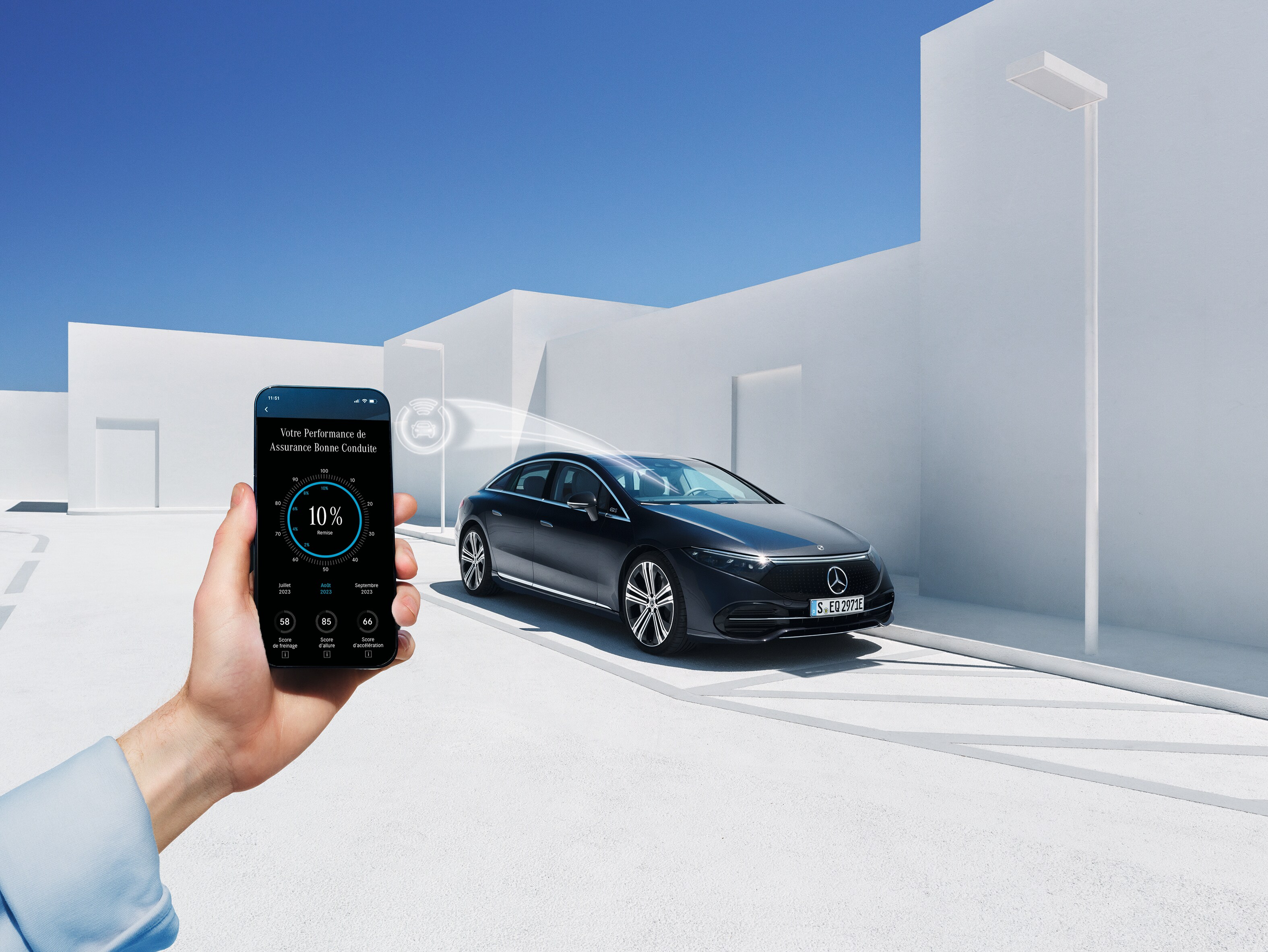 Une femme regarde son téléphone portable à coté d'une Mercedes Benz EQC