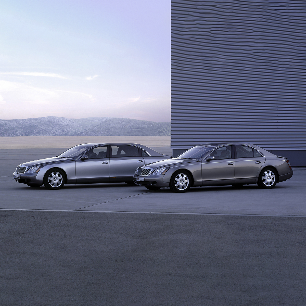 2002 Deux Mercedes-Benz électriques stationnées devant un bâtiment moderne.
