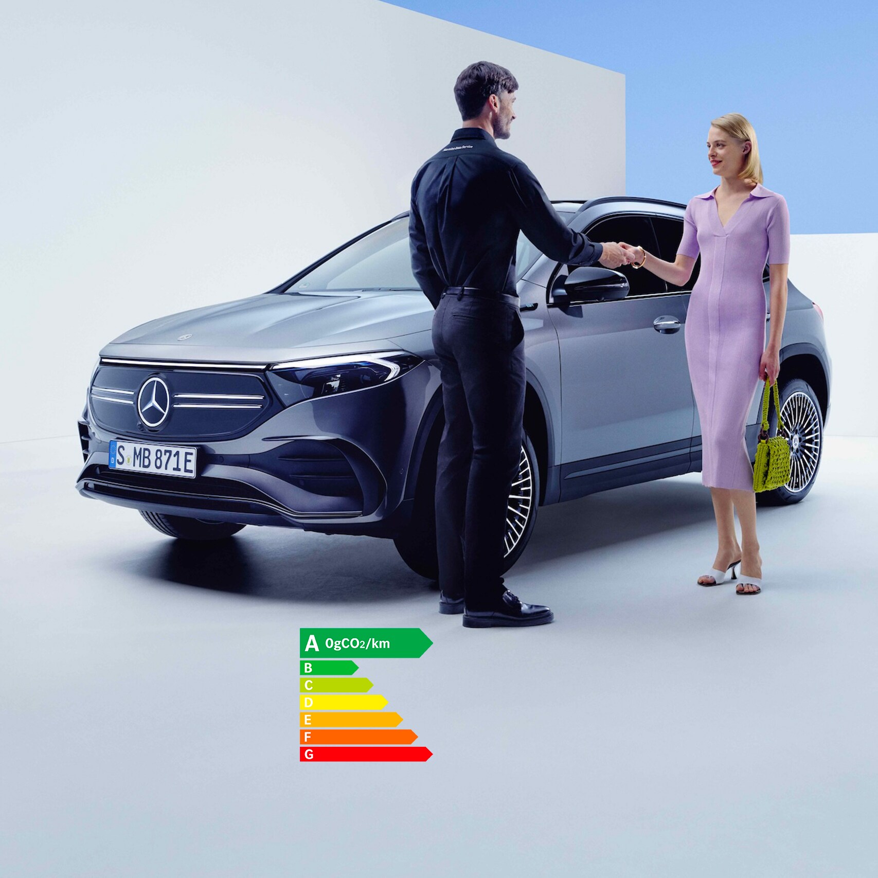 Un employé de Mercedes-Benz et une femme se serrent la main devant un véhicule Mercedes-Benz