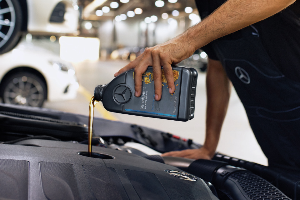 Huile moteur d'origine Mercedes-Benz Gros plan sur le compartiment moteur pendant le remplissage avec de l'huile moteur d'origine Mercedes-Benz.