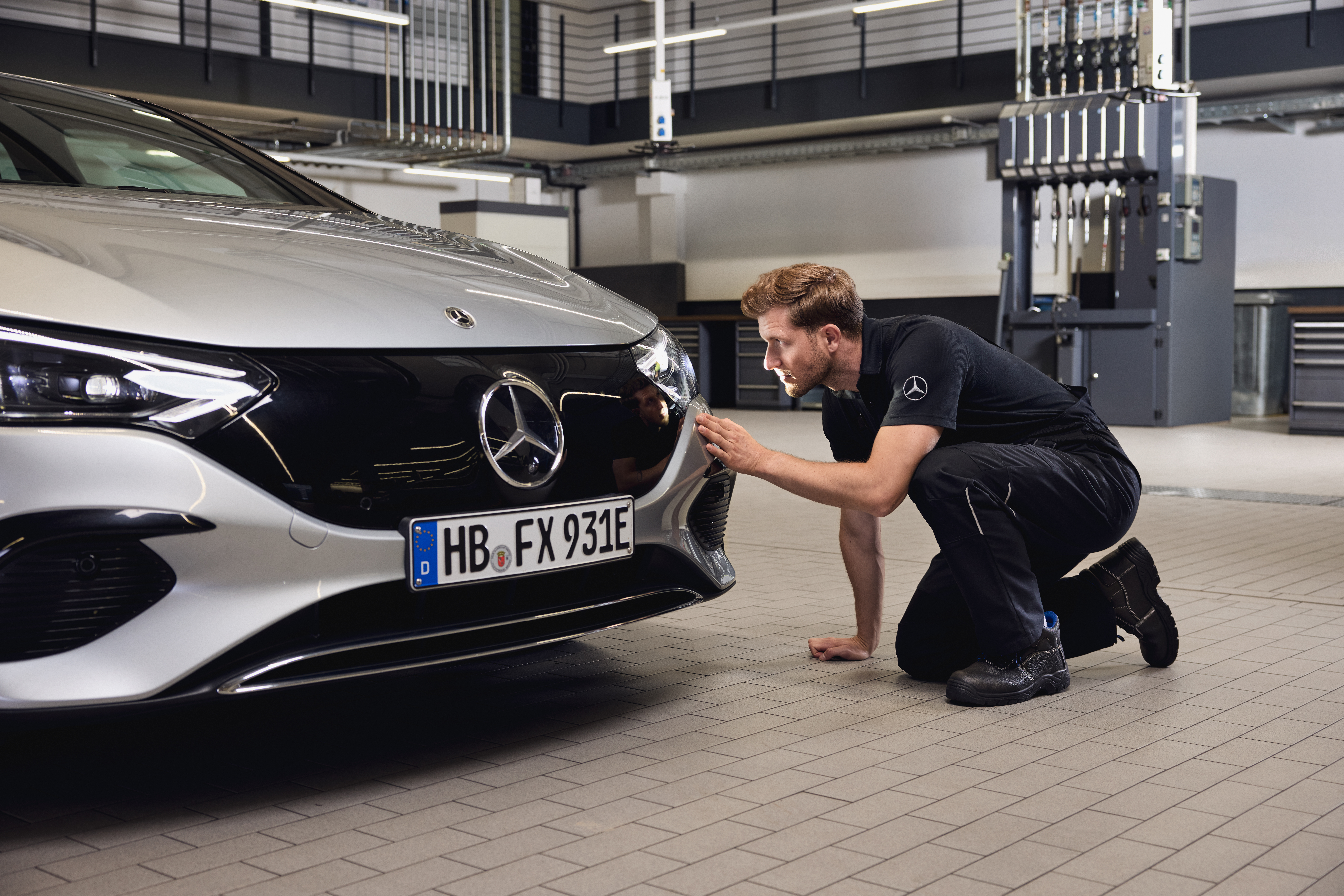 Remplacement des phares d'origine Mercedes-Benz Gros plan sur l'avant d'un véhicule Mercedes-Benz, avec un technicien procédant à un contrôle minutieux lors du remplacement de pièces d'origine Mercedes-Benz.