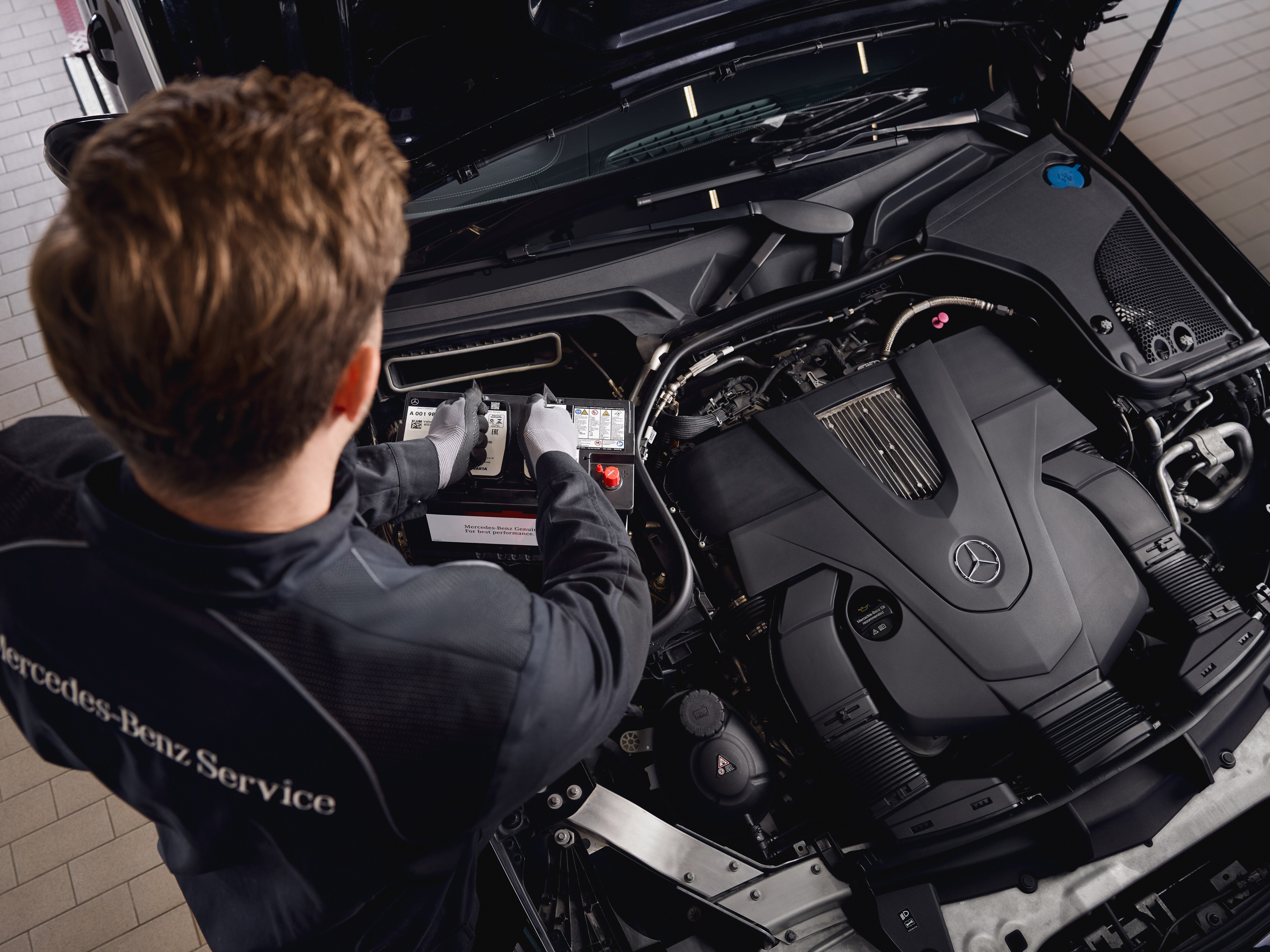 Maintenance du moteur en atelier, montrant le remplacement de composants par des pièces d'origine Mercedes-Benz.