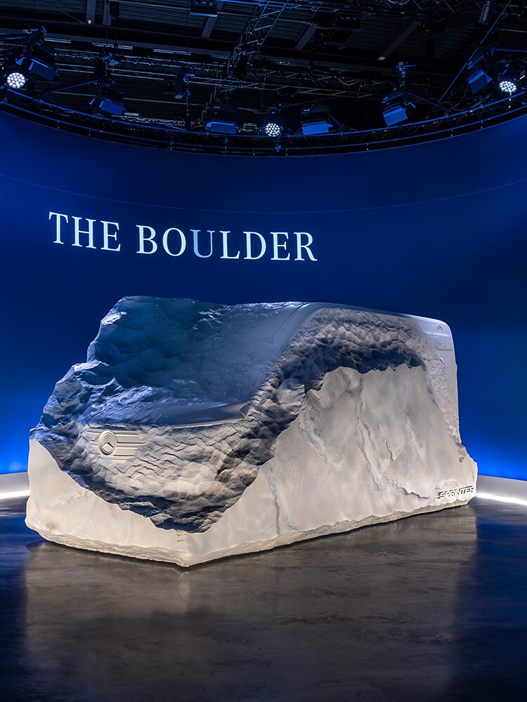 Concept Mercedes-Benz recouvert d'une housse dans un espace d'exposition avec l'inscription « The Boulder ».