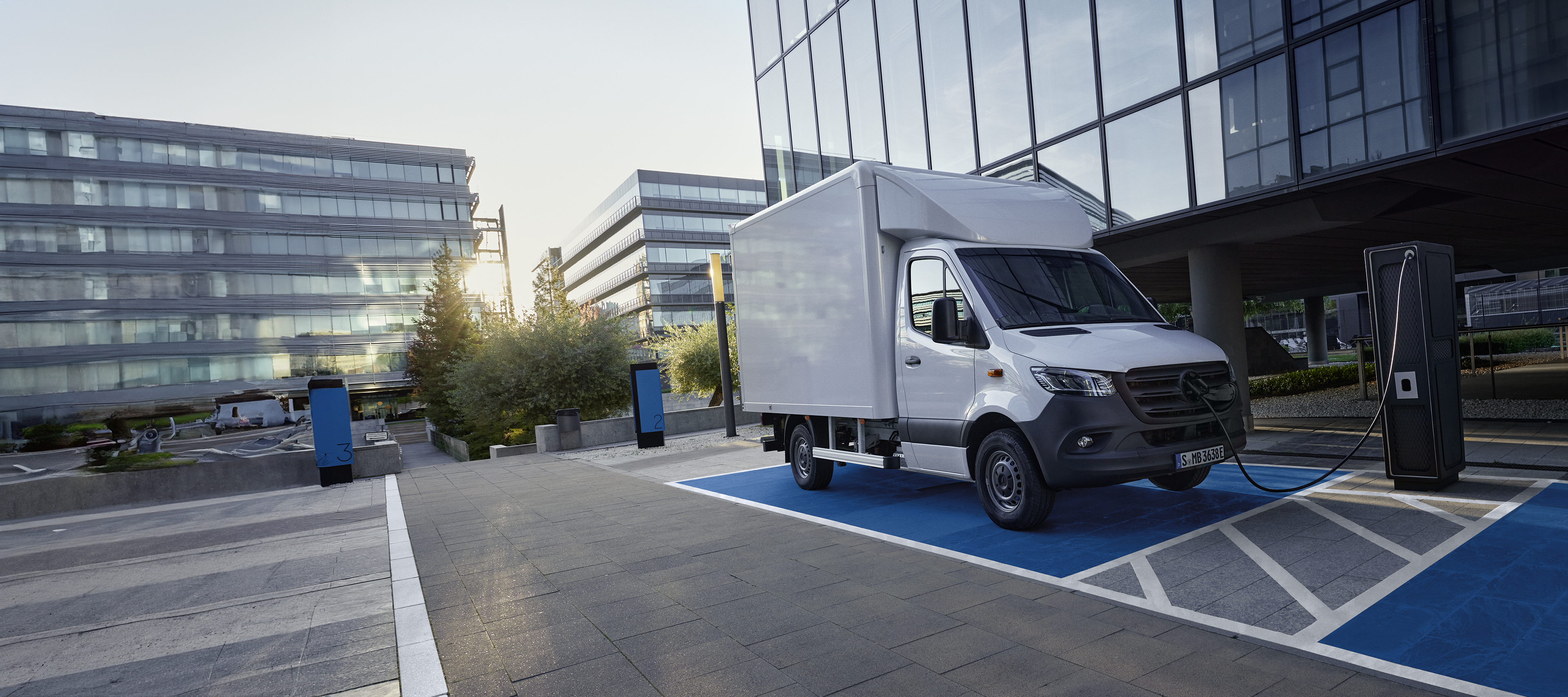 Leasing & Financement | eSprinter châssis-cabine | Mercedes-Benz Le Mercedes-Benz eSprinter châssis-cabine en version véhicule à plateau en déplacement en ville.