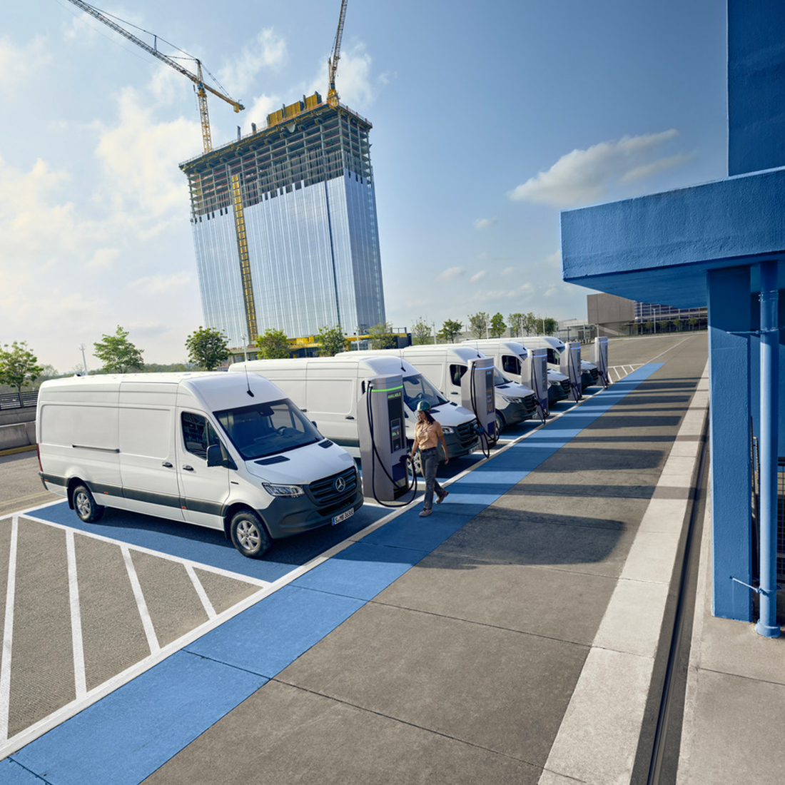 Une femme debout devant un véhicule Mercedes-Benz EQ avec l'hyper-écran qui se trouve au-dessus d'elle. Hyper-écran Mercedes-Benz