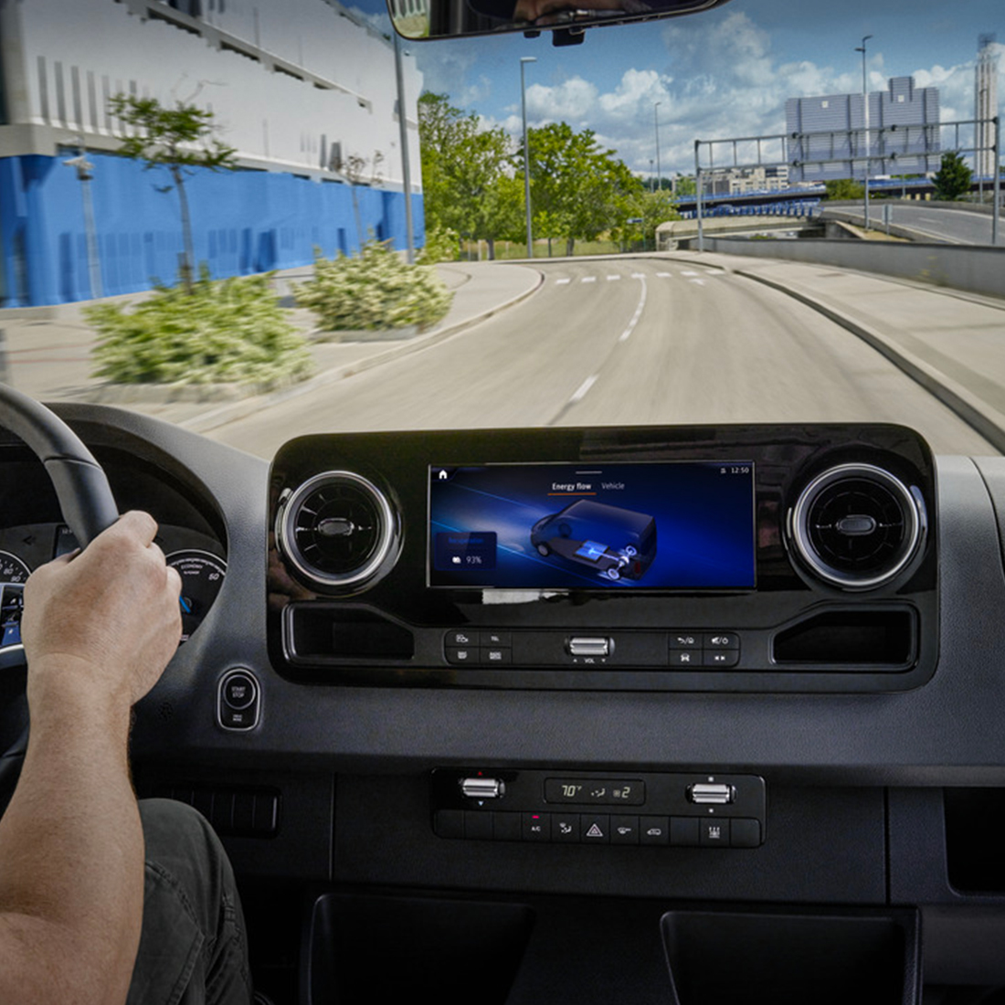 Une femme debout devant un véhicule Mercedes-Benz EQ avec l'hyper-écran qui se trouve au-dessus d'elle. Hyper-écran Mercedes-Benz