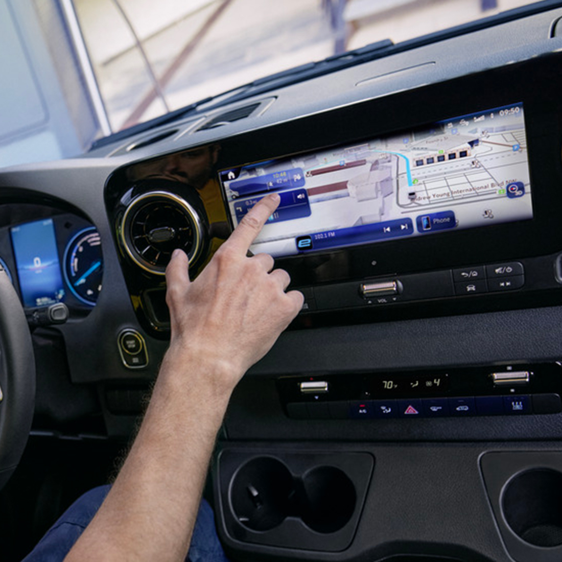 Une femme debout devant un véhicule Mercedes-Benz EQ avec l'hyper-écran qui se trouve au-dessus d'elle. Hyper-écran Mercedes-Benz