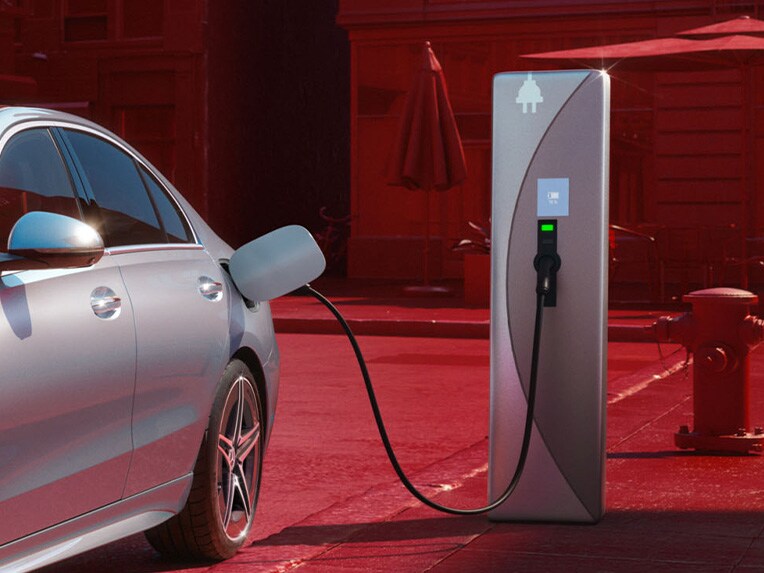 La photo montre la Mercedes-Benz Classe C Berline hybride rechargeable en cours de recharge sur une borne de recharge publique.