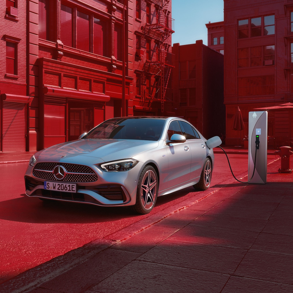 Vue dynamique d'une Mercedes-Benz Classe C Berline (en mouvement) ou stationnée à une borne de recharge.
