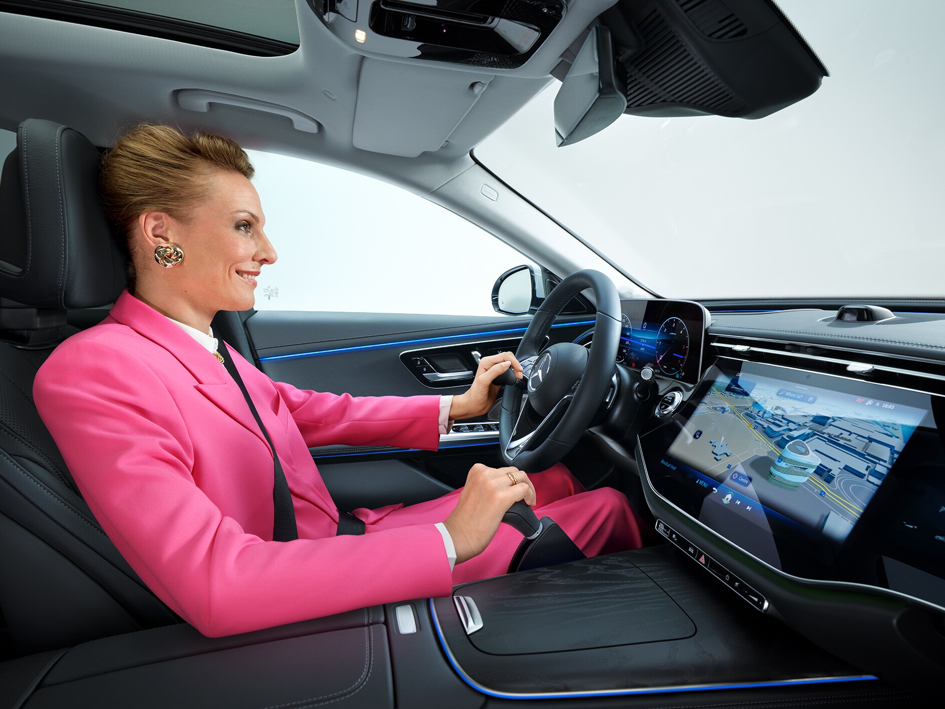 Vue latérale d'une Classe E transformé en voiture pour personnes à mobilité réduite, avec au premier plan une femme en fauteuil roulant tenant un smartphone.