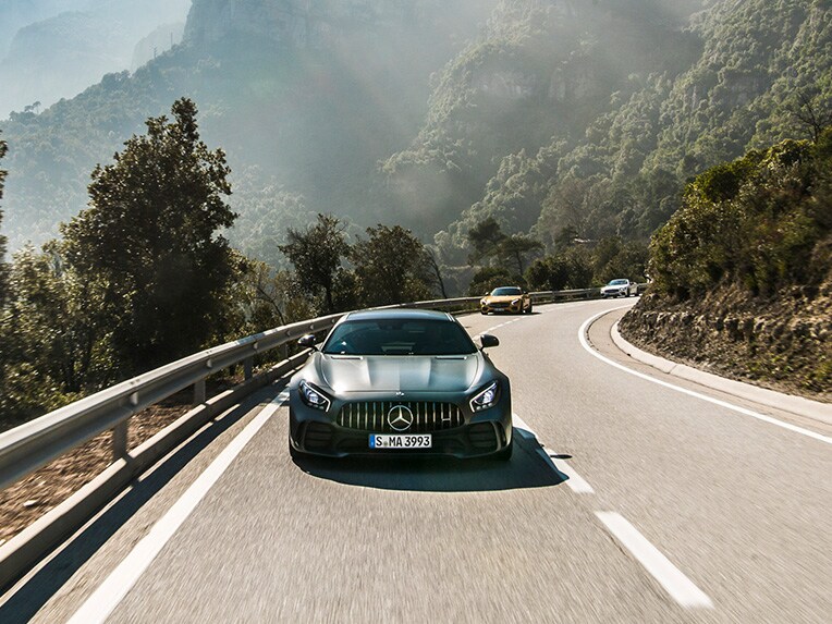 Une Mercedes-AMG GT R vue de face roulant sur une route.