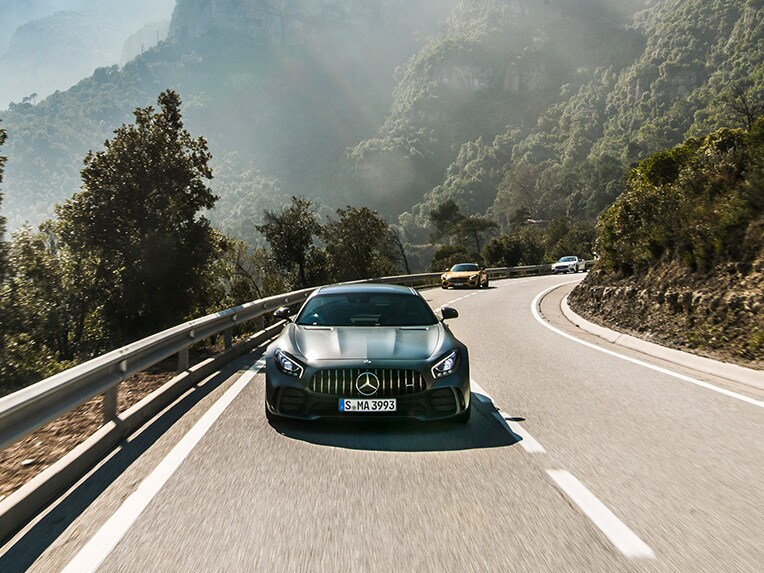 Une Mercedes-AMG GT R vue de face roulant sur une route.