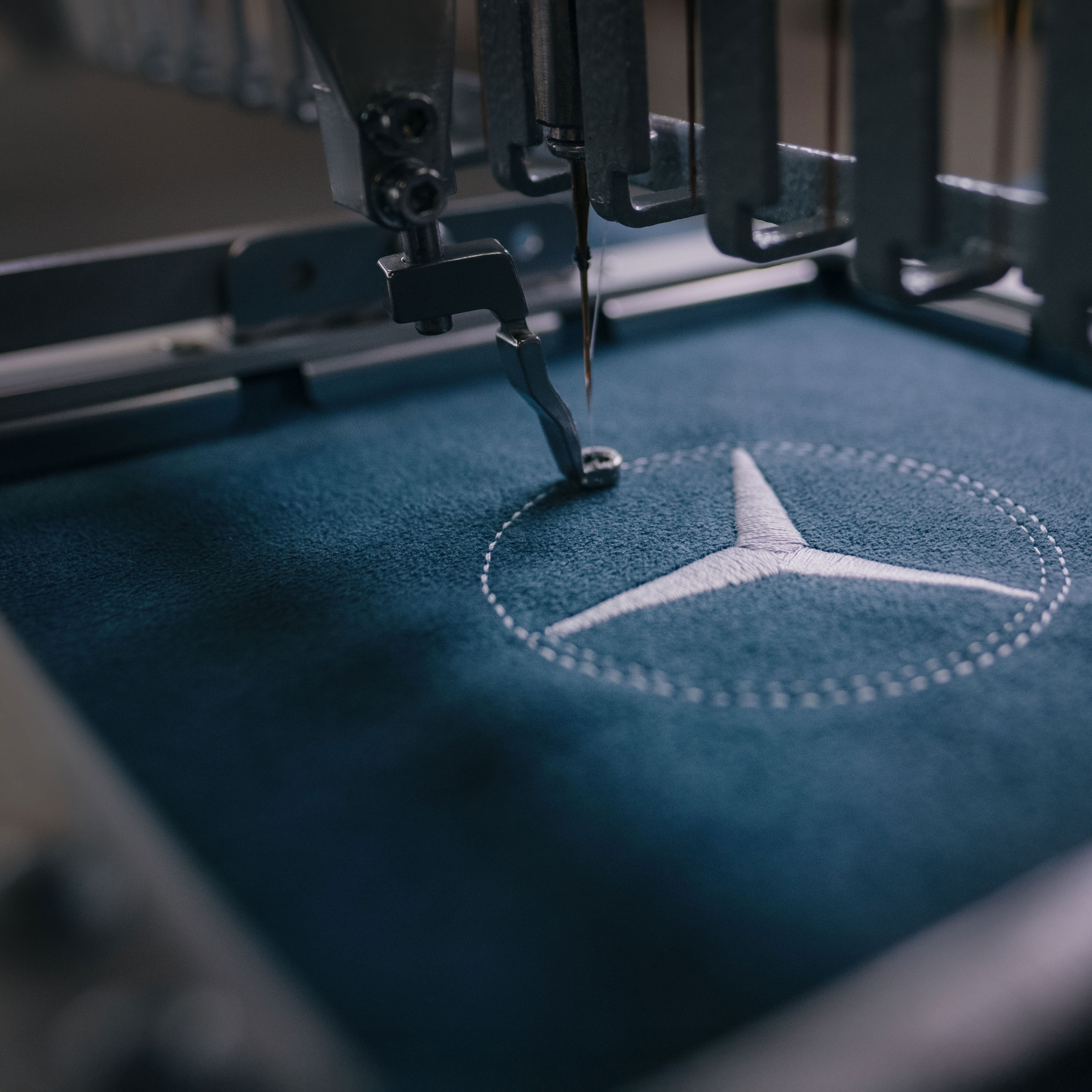MANUFAKTUR | Mercedes-Benz L'étoile Mercedes-Benz est cousue sur le tissu.