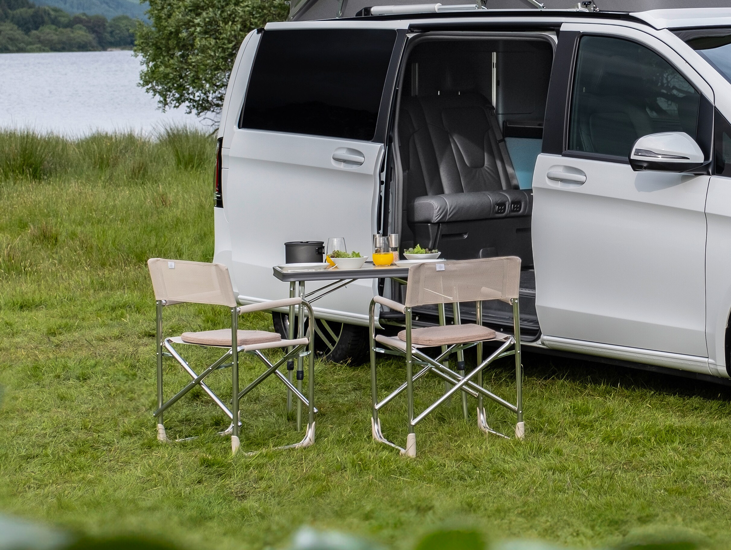 La Classe V Marco Polo avec table de camping et 2 chaises.