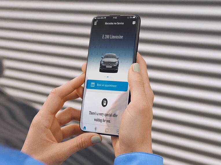 Un smartphone et une vue détaillée des phares d'un véhicule Mercedes-Benz.
