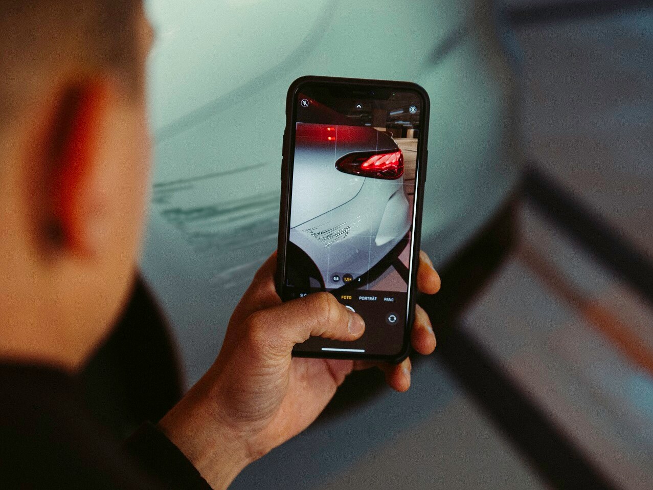 Un conducteur de Mercedes-Benz documente les dégâts du véhicule avec son smartphone.