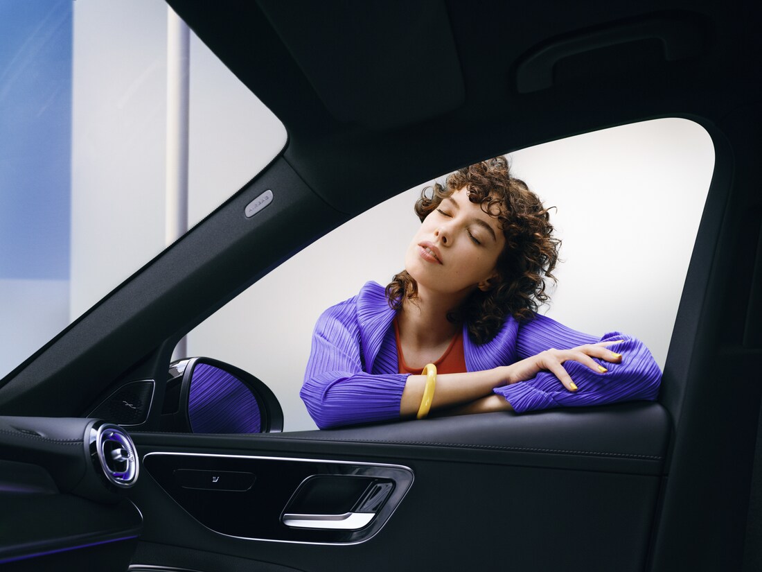 Une femme apprécie la propreté de sa Mercedes-Benz.