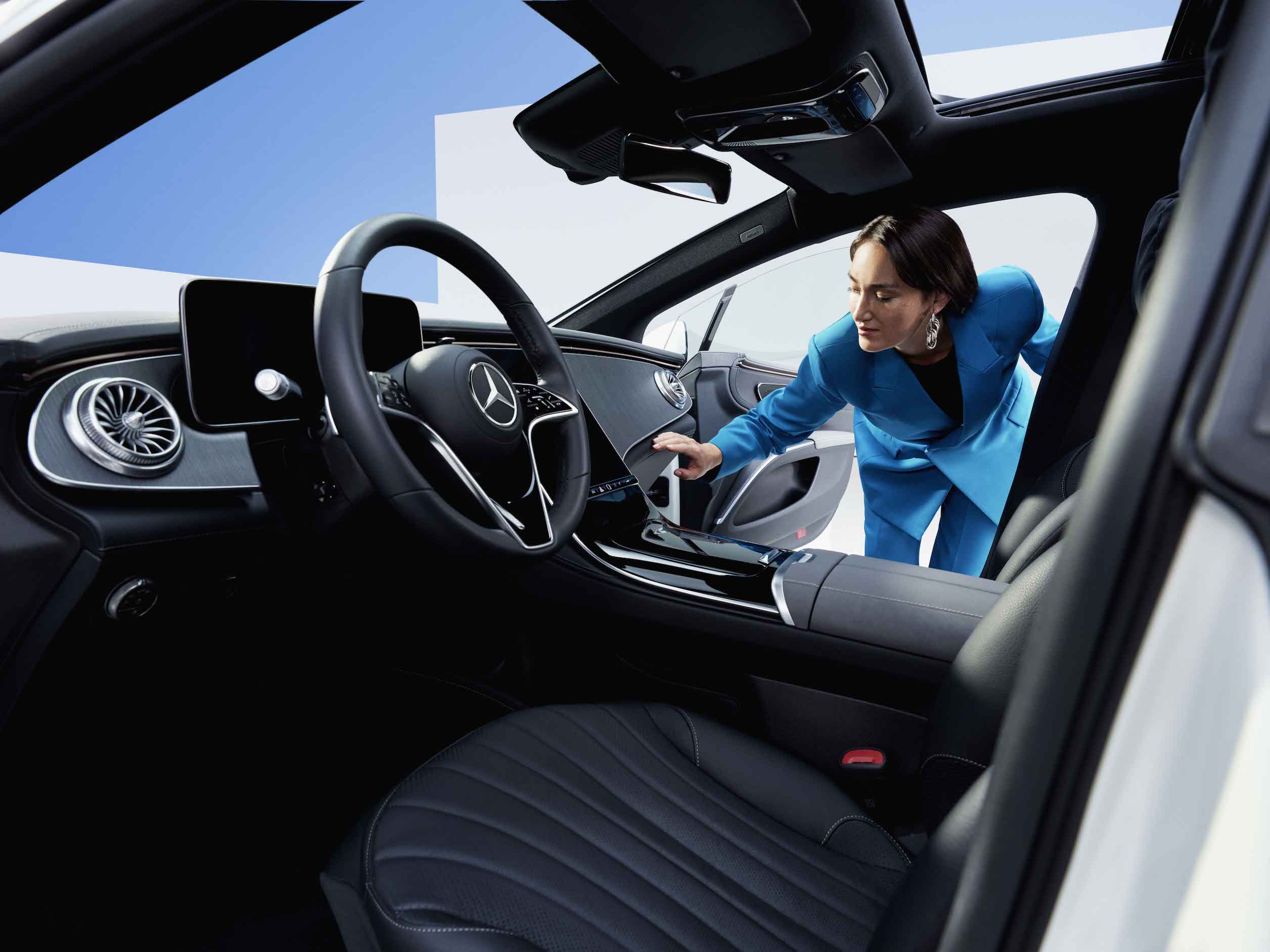 Mercedes-Benz | Produits d’entretien d’origine Une femme examine l’habitacle propre d’une Mercedes-Benz.