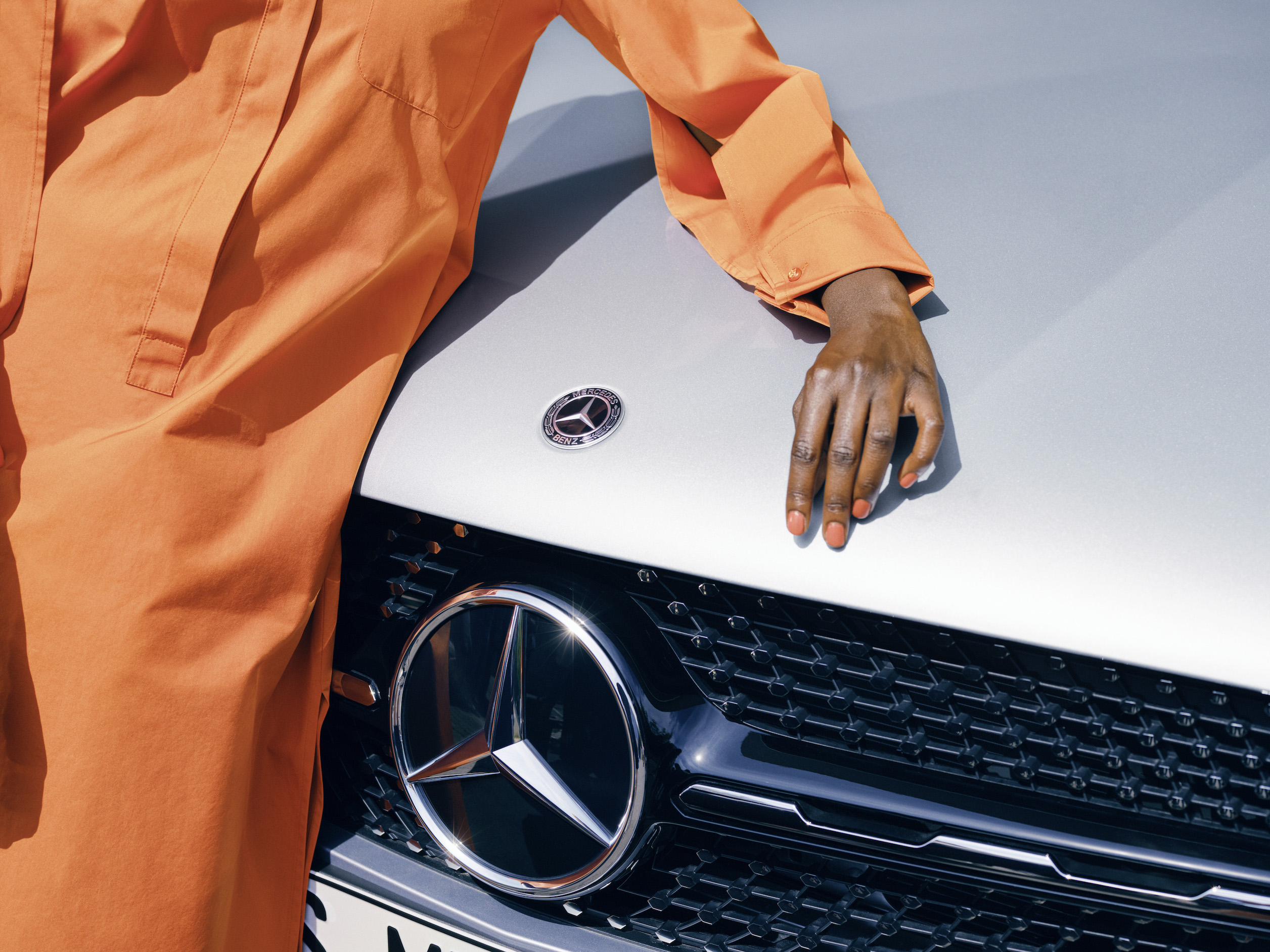 Mercedes-Benz | Produits d’entretien d’origine Une femme admire la peinture de sa Mercedes-Benz.