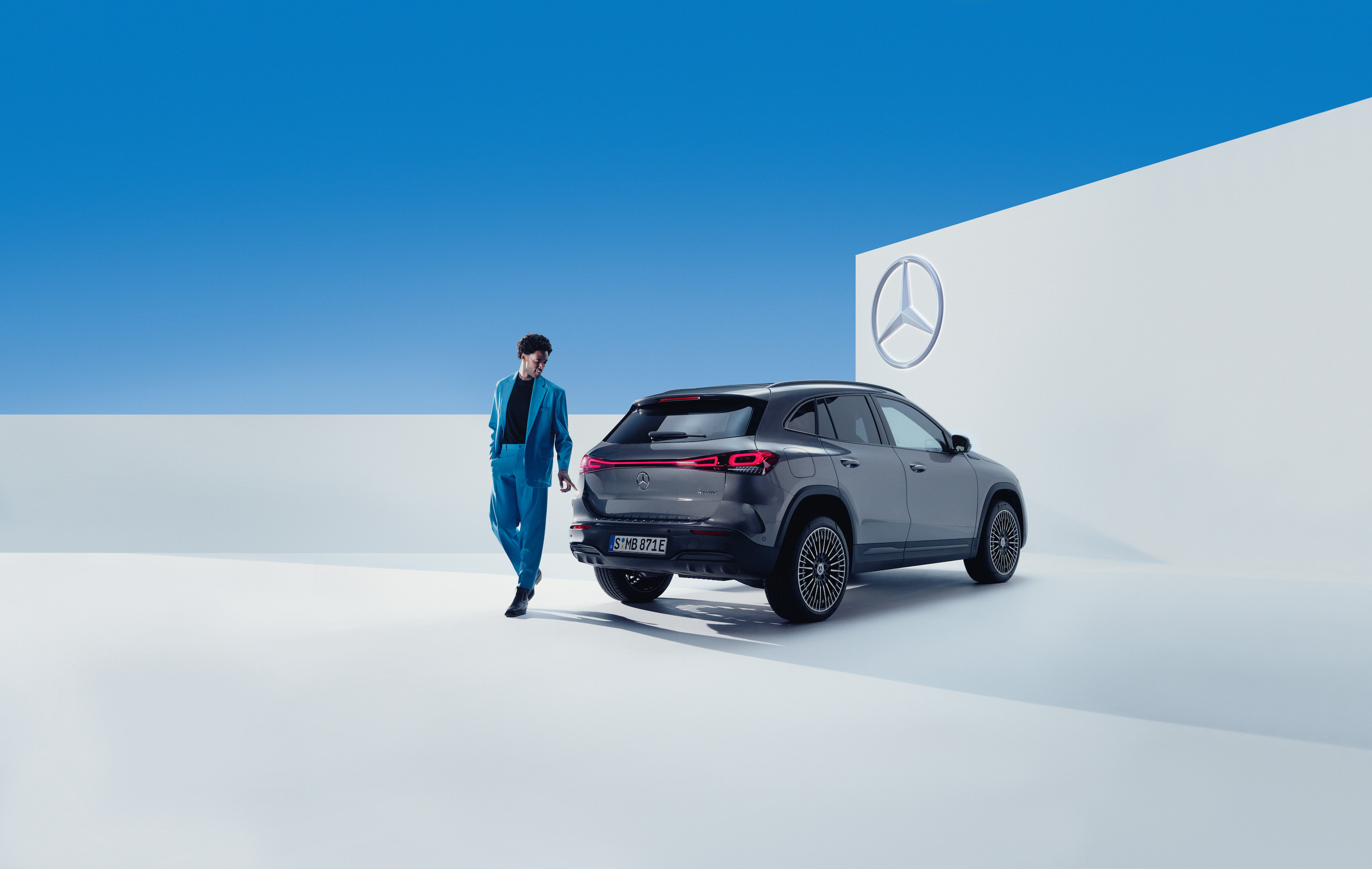 Mercedes-Benz | Produits d’entretien d’origine Un homme marche à côté de sa Mercedes-Benz.