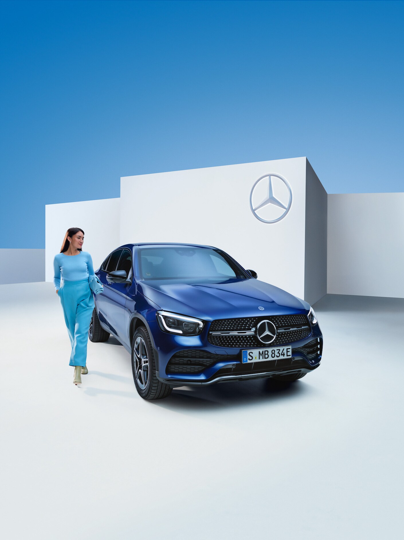 Une femme est à côté de sa Mercedes-Benz.