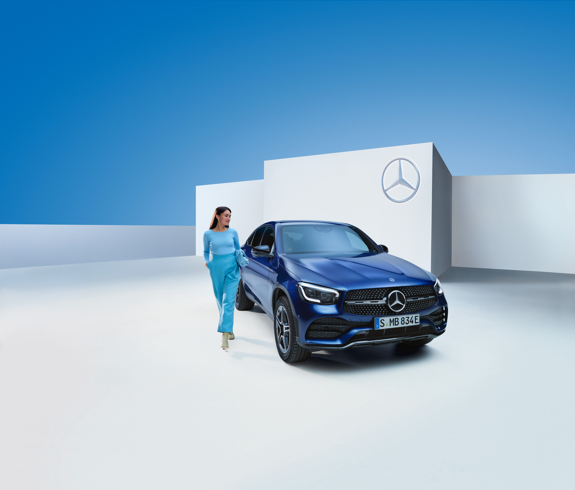 Mercedes-Benz | Produits d’entretien d’origine Une femme est à côté de sa Mercedes-Benz.