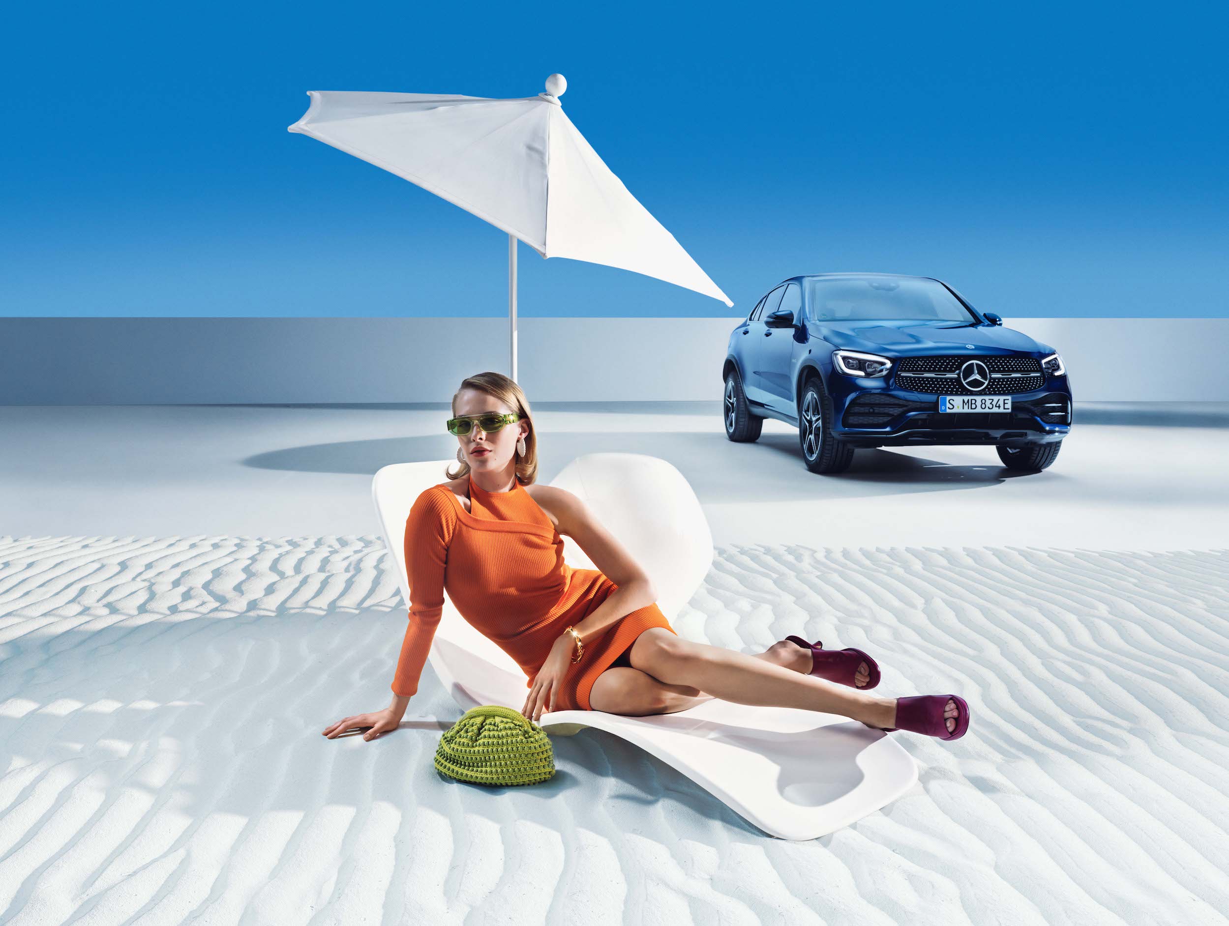 Mercedes-Benz | Produits d’entretien d’origine Une femme se détend sur la plage devant sa Mercedes-Benz.