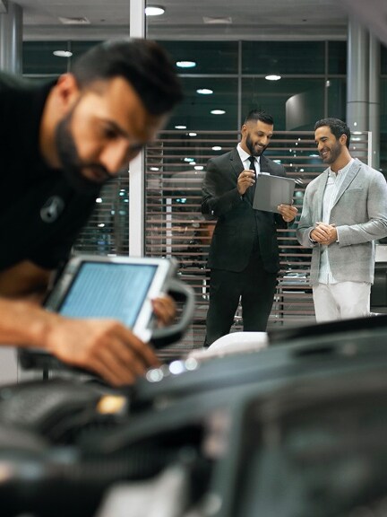 Un technicien Mercedes-Benz contrôle la batterie du réseau de bord dans le véhicule.