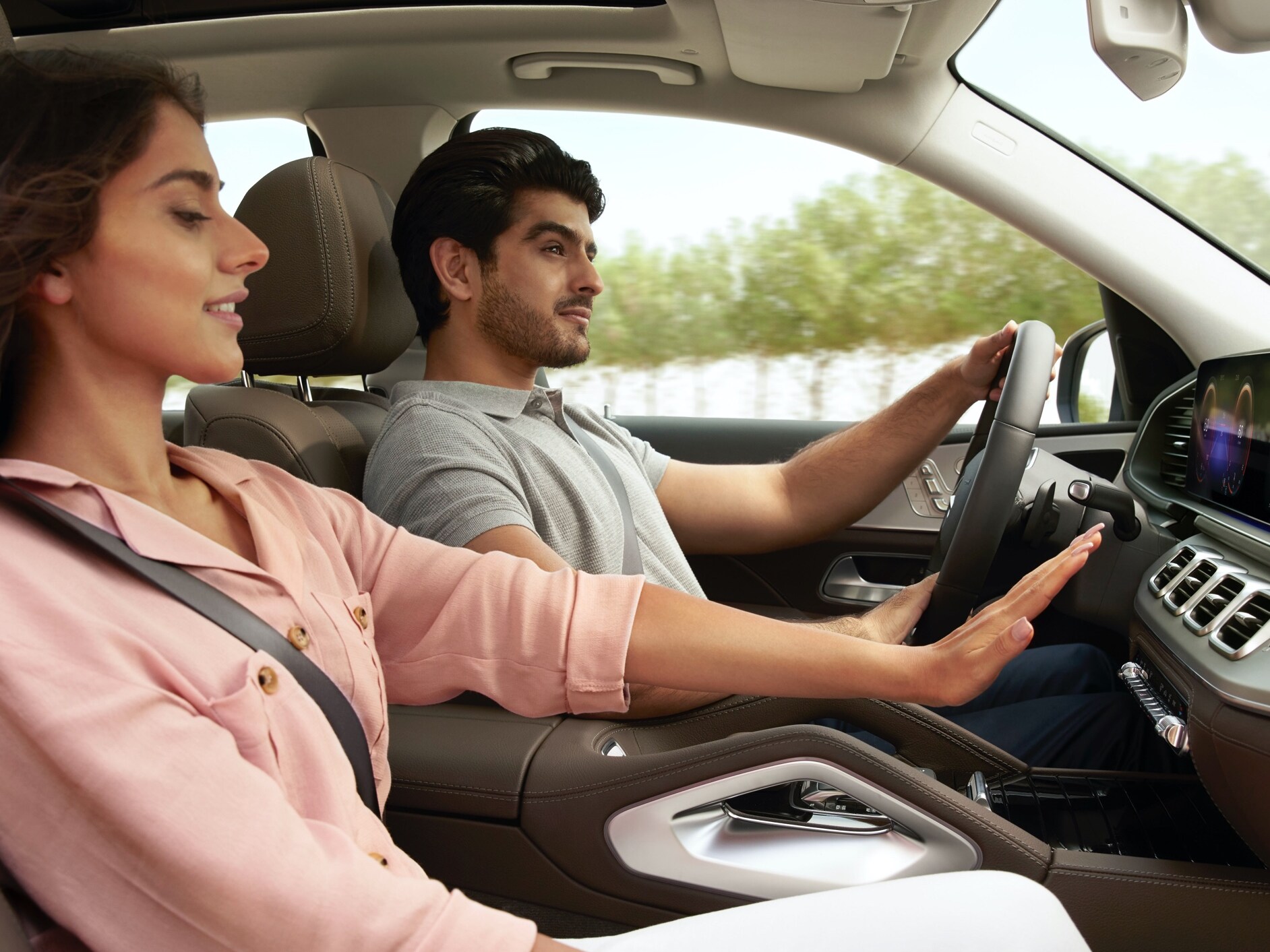 Une femme lève la main devant les fentes d'aération du système de climatisation de sa Mercedes-Benz.