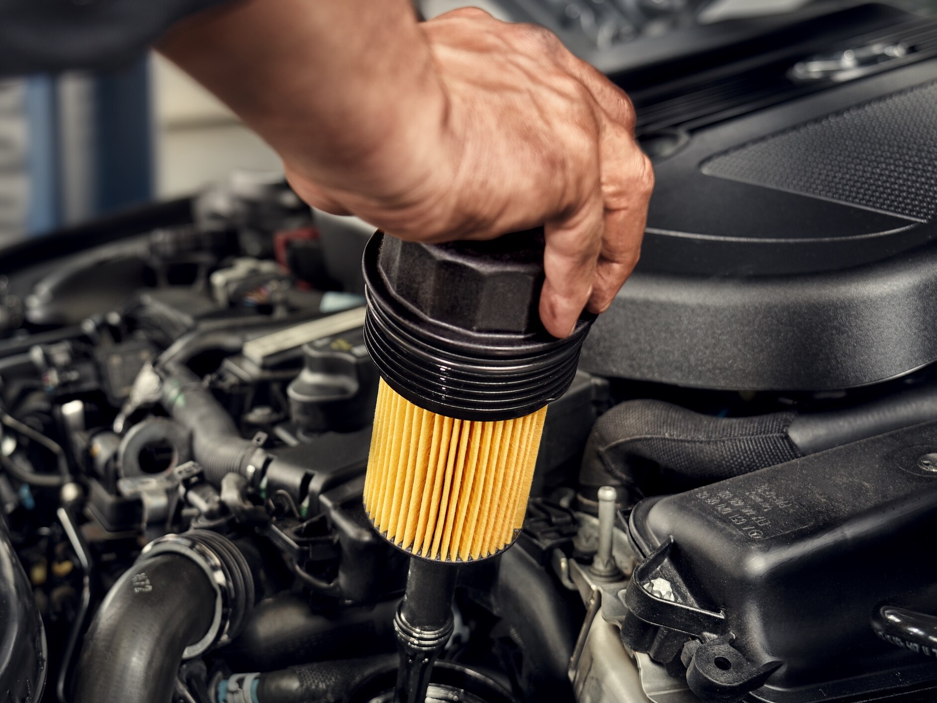 Un technicien installant le filtre à huile sur un véhicule Mercedes-Benz.