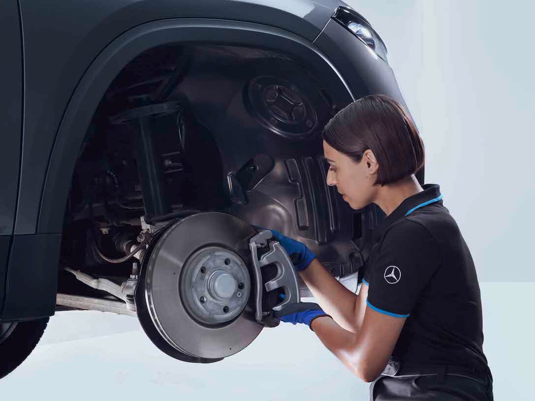 Une Mercedes-Benz stationnée devant quelques étagères où sont entreposées des roues.