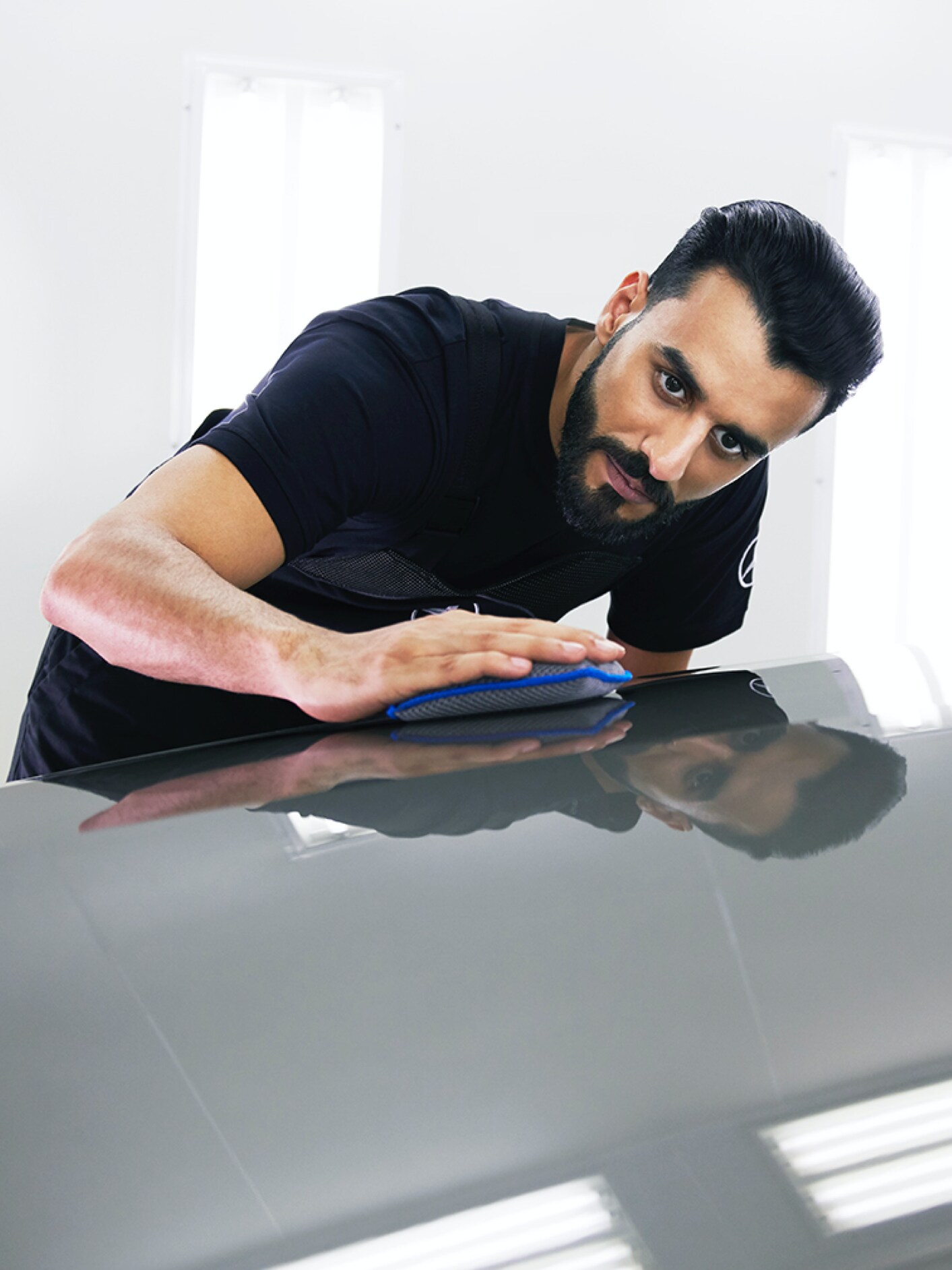 Un technicien Mercedes-Benz vérifie que le capot ne présente pas de petits dommages.