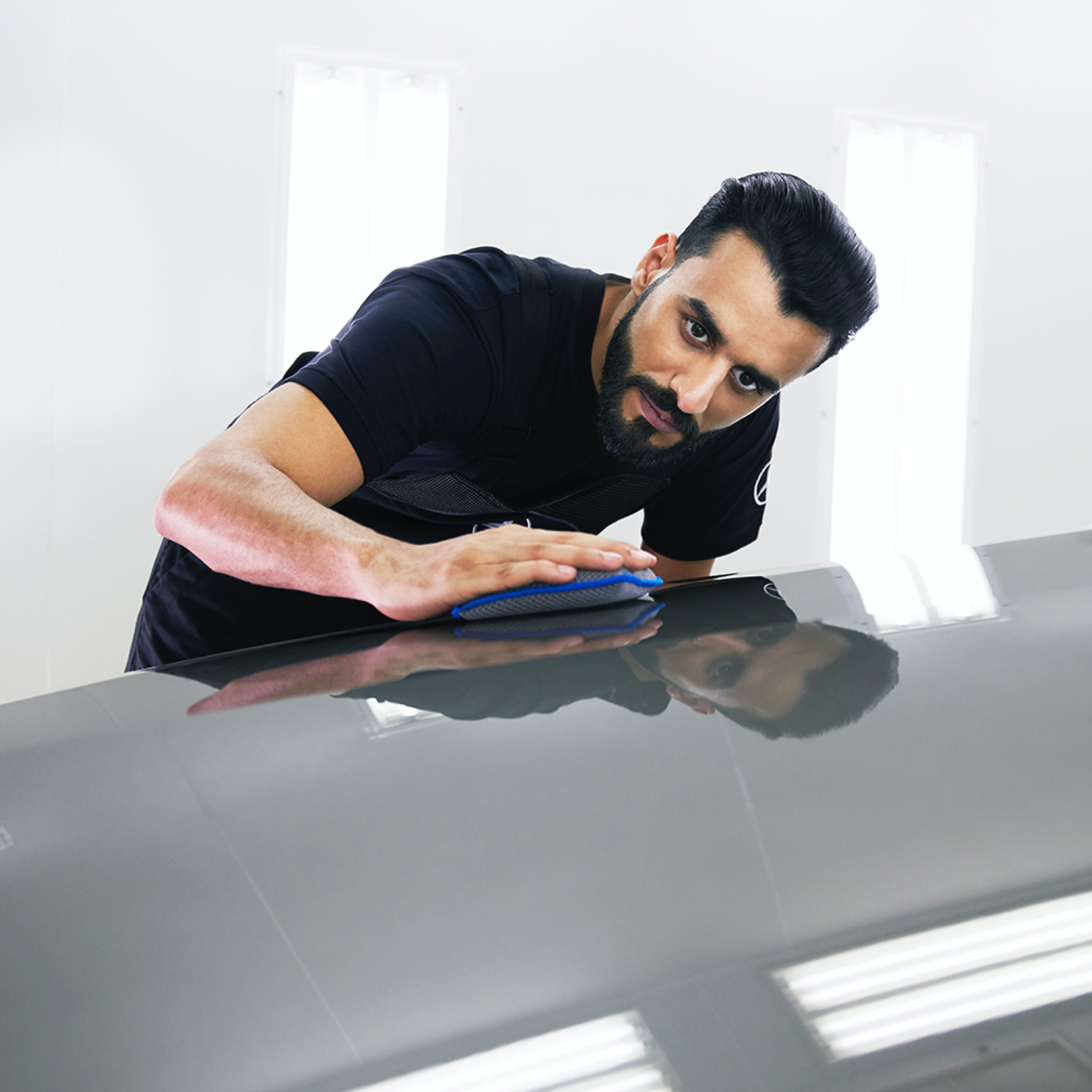SmallRepair Un technicien Mercedes-Benz vérifie que le capot ne présente pas de petits dommages.