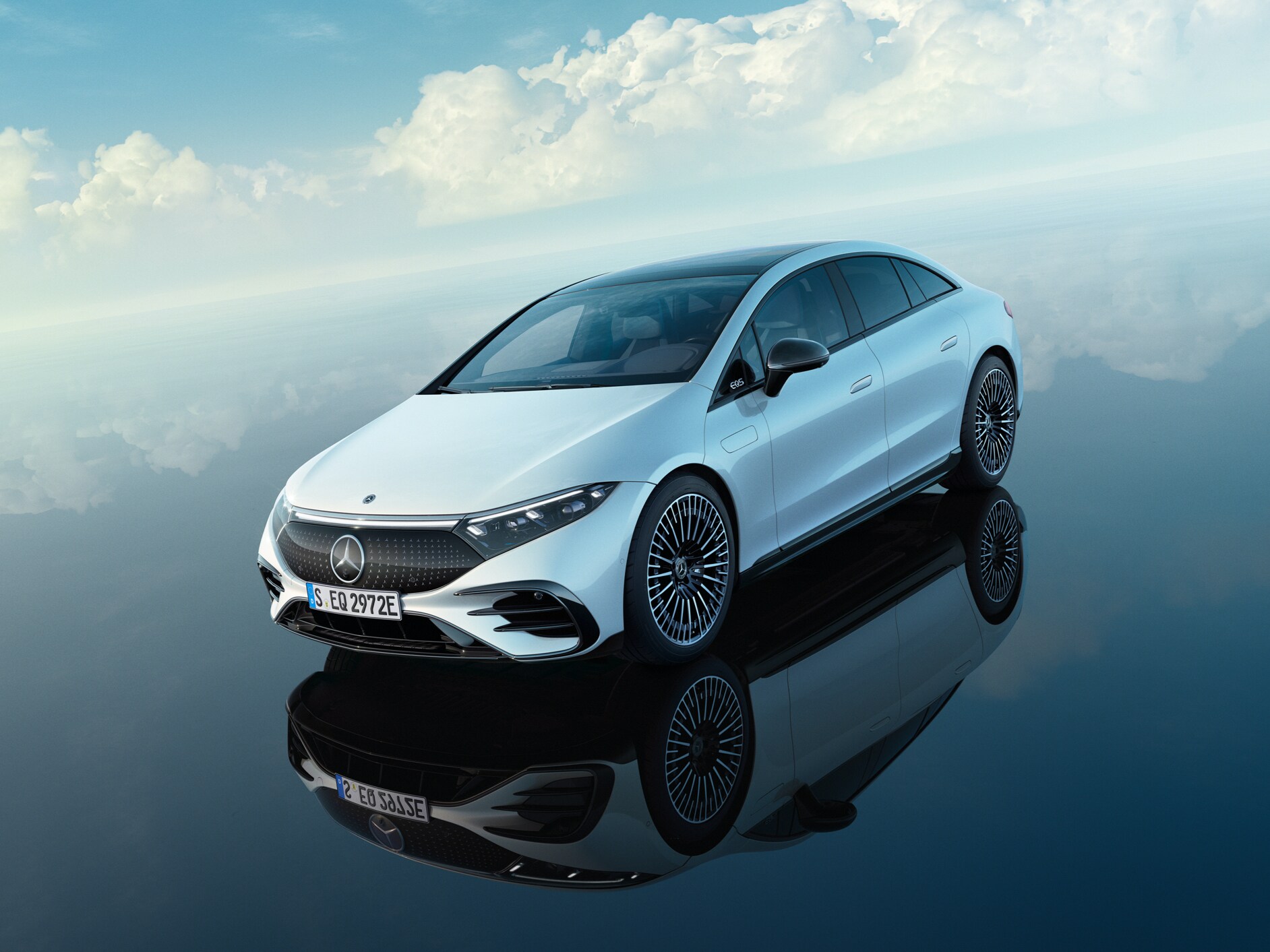 Une Mercedes 100% électrique blanche est garée sous un ciel d'un bleu éclatant.