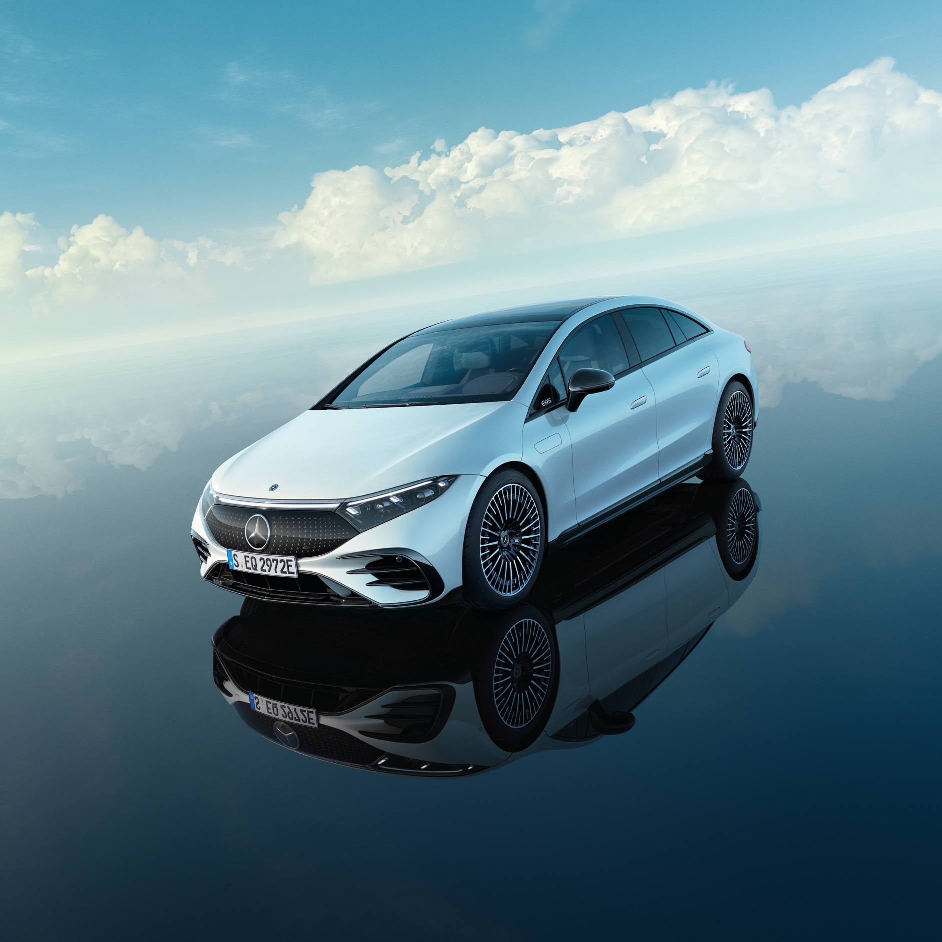 Un examen minutieux. Une Mercedes 100% électrique blanche est garée sous un ciel d'un bleu éclatant.