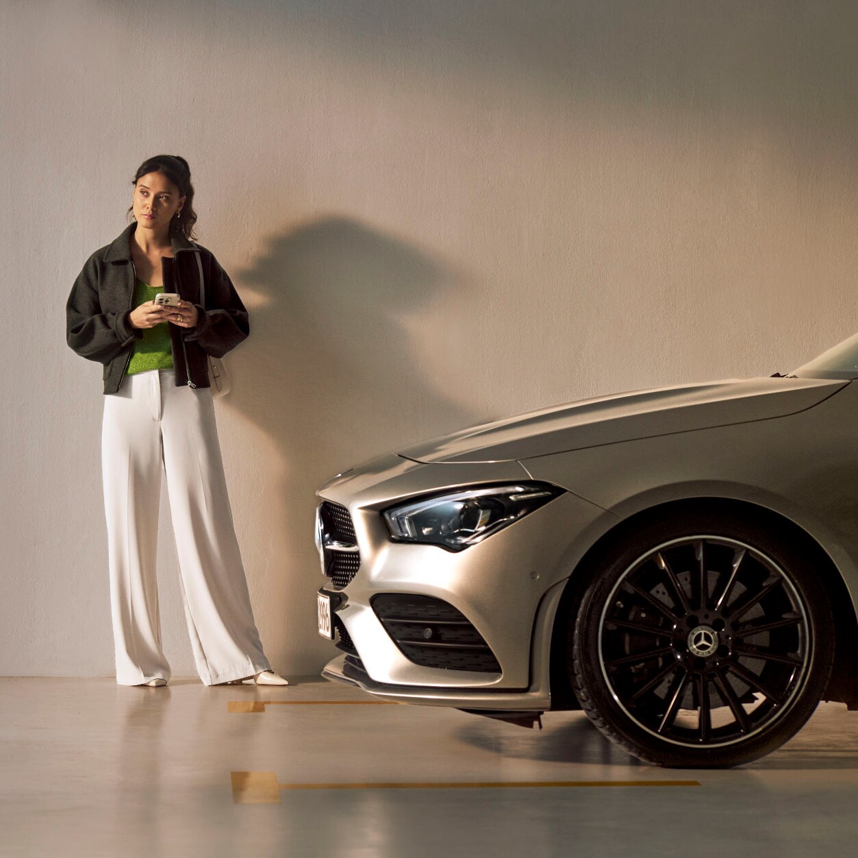 Une femme se tient devant un véhicule Mercedes-Benz.