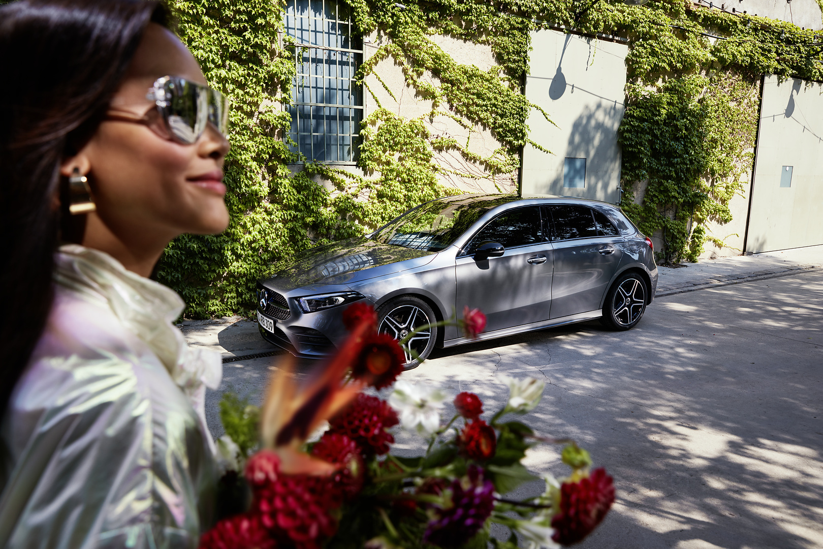 Rassurant comme Mercedes ServiceCare. | Mercedes-Benz Des fleurs à la main, une femme détendue se dirige vers sa Mercedes entretenue.