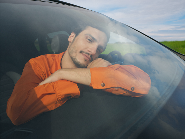Un jeune homme se détend dans sa Mercedes-Benz.
