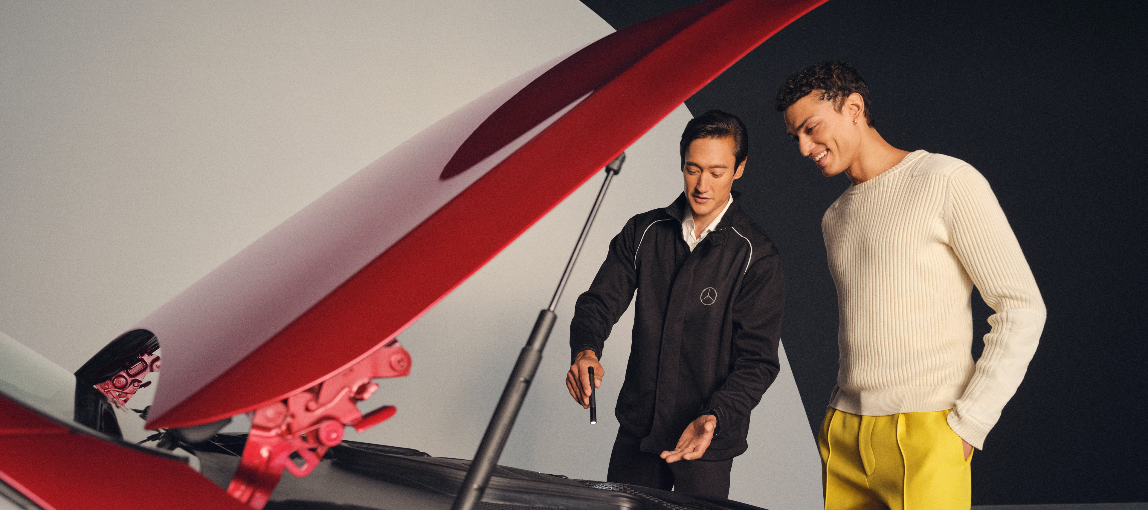 Services de maintenance de Mercedes-Benz Mécanicien Mercedes-Benz et un homme se tiennent devant le capot ouvert d'une Mercedes-Benz.