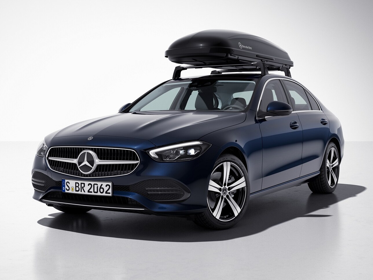 Un coffre de toit Mercedes-AMG noir est installé sur le toit d'un véhicule Mercedes-Benz bleu.