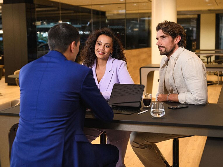 Conseiller Mercedes-Benz recevant un couple pour un rendez-vous dans un showroom.