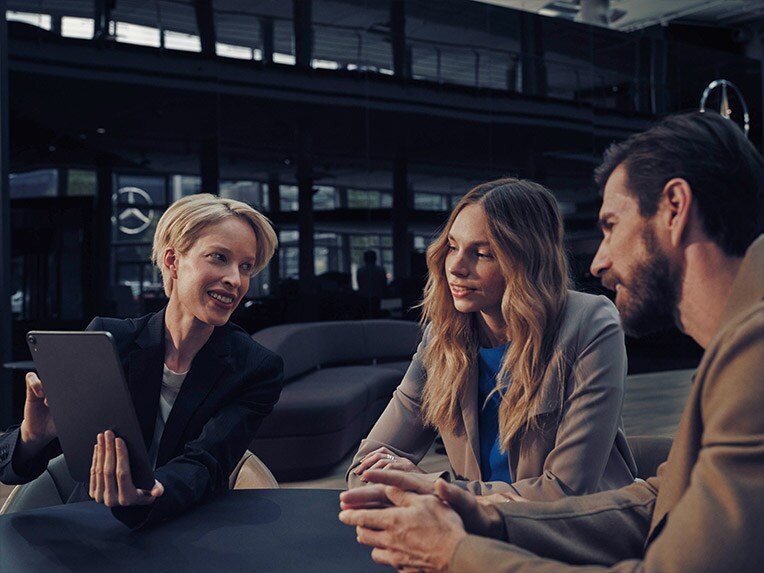 Homme et femme à une table avec un distributeur Mercedes-Benz