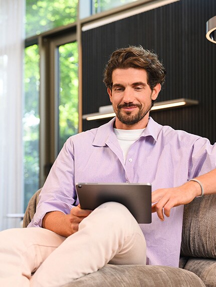 Femme parlant au téléphone portable à côté du monospace Mercedes-Benz EQV noir