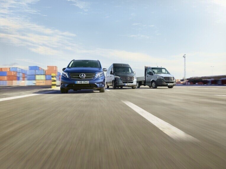 Les utilitaires légers Mercedes-Benz Vito et Sprinter roulent sur une route avec des conteneurs maritimes en arrière-plan.