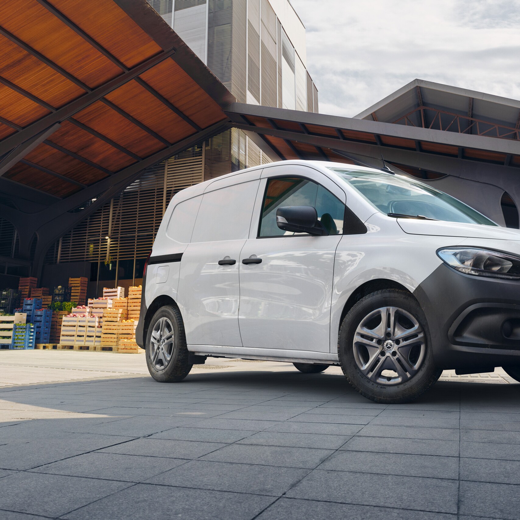 Le Mercedes-Benz Citan fourgon en ville devant le mur d'une maison.
