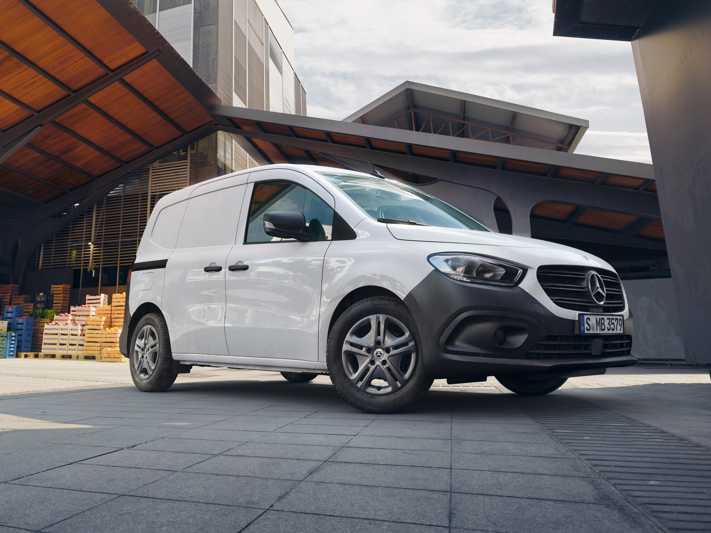 Mercedes-Benz Fourgon d'occasion blanc stationné devant un bâtiment moderne.